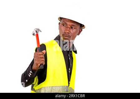 Junger Techniker trägt grüne Weste und Schutzhelm und hält einen Schraubendreher. Stockfoto