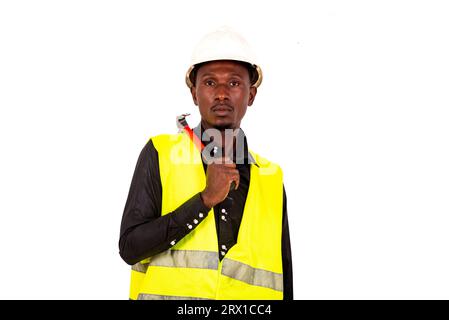Junger Techniker mit grüner Weste und Schutzhelm mit Hammer. Stockfoto