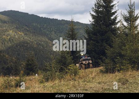 ATV in bergigem Gelände, Blick auf den Wald in den Bergen Stockfoto