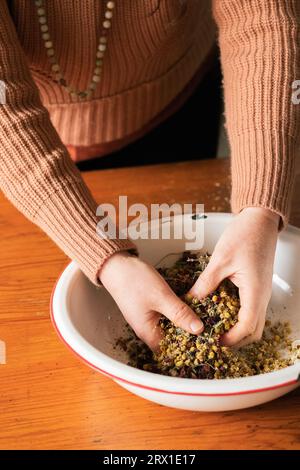 Frau mischte lose Blattkräuter in einer Schüssel. Stockfoto