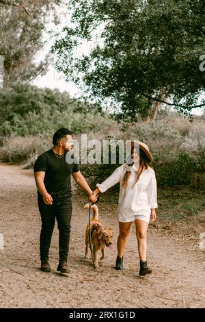 Junge Paar, der Hund im Wald läuft Stockfoto