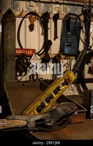 Ein gelbes Kontrollfeld und eine verlassene, rostige, industrielle Bergbauausrüstung, die in Mine 3 in Longyearbyen, Svalbard, verblieben sind Stockfoto