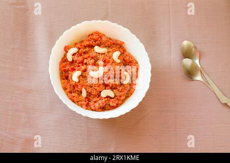 Gajar Halwa oder Karotte Halwa, traditionelles indisches Wintersüß, Dessert garniert mit Mandeln, Rosinen, Nüssen. Diwali, Dussehra, Navratri Spezial. Stockfoto