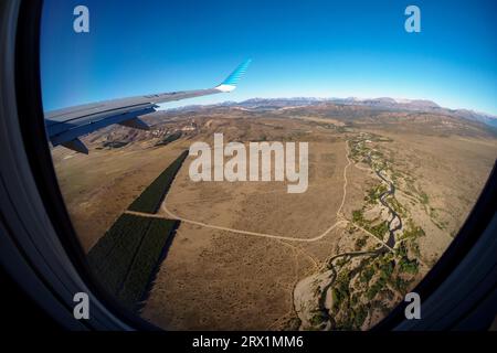 Blick von der Ebene der patagonischen Steppe mit einem Fluss und einer Kiefernplantage in der Nähe von Bariloche, Patagonien, Argentinien Stockfoto