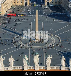 Blick aus der Vogelperspektive auf den antiken ägyptischen Vatikanischen Granitobelisken auf dem Petersplatz in den vorderen Skulpturen Statuen von Heiligen auf dem Hauptportal des Dachs Stockfoto