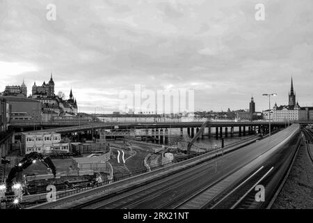 Ein Zug auf einer Bahnstrecke mit Gebäuden im Hintergrund Stockfoto