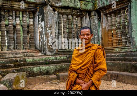 Lächelnder buddhistischer Mönch vor alten Fenstern mit Säulen, Prasat Krahom (Roter Tempel), Koh Ker, Provinz Preah Vihear, Kambodscha. © Kraig Lieb Stockfoto