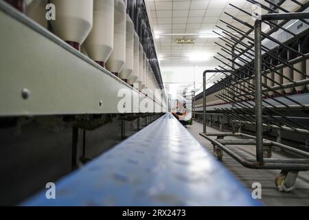 Luannan County, China - 5. September 2022: Arbeiter warten Spinnereien in einer Spinnerei. Stockfoto