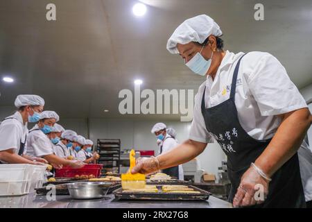 Luannan County, China - 8. September 2022: Der Arbeiter ölt die Mondkuchenhaut zum Backen. Stockfoto