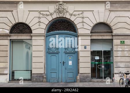 LJUBLJANA, SLOWENIEN - 7. MÄRZ 2023: Dies ist ein Fragment der Fassade eines alten Barockhauses mit geschnitzten Holztüren und dekorativer Dekoration darüber Stockfoto