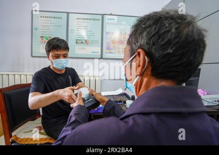 Luannan County, China - 15. September 2022: Arbeiter debuggen Hörgeräte für Behinderte, Nordchina Stockfoto