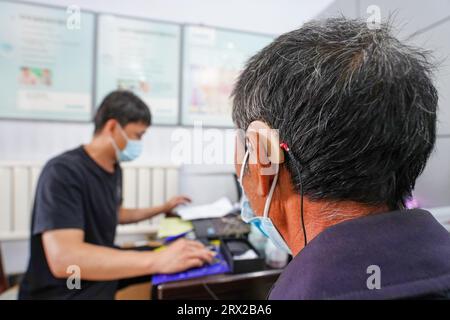 Luannan County, China - 15. September 2022: Arbeiter debuggen Hörgeräte für Behinderte, Nordchina Stockfoto