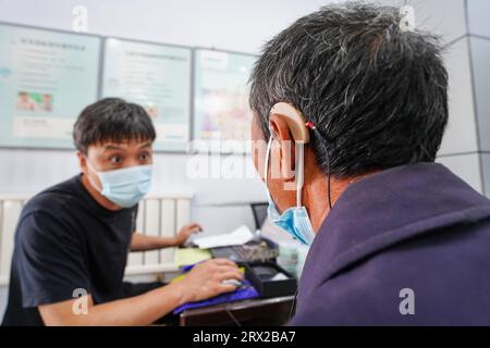 Luannan County, China - 15. September 2022: Arbeiter debuggen Hörgeräte für Behinderte, Nordchina Stockfoto