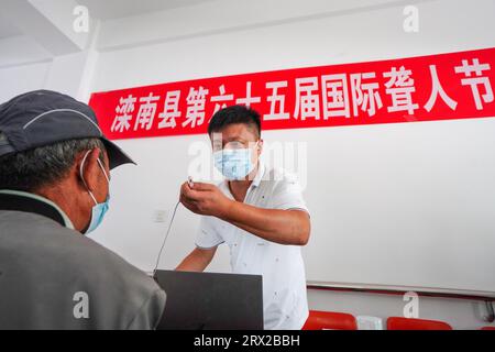 Luannan County, China - 15. September 2022: Arbeiter debuggen Hörgeräte für Behinderte, Nordchina Stockfoto