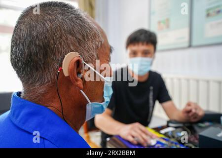 Luannan County, China - 15. September 2022: Arbeiter debuggen Hörgeräte für Behinderte, Nordchina Stockfoto