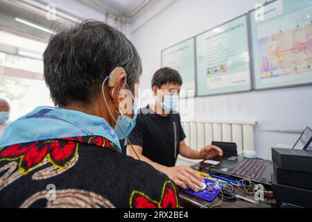 Luannan County, China - 15. September 2022: Arbeiter debuggen Hörgeräte für Behinderte, Nordchina Stockfoto