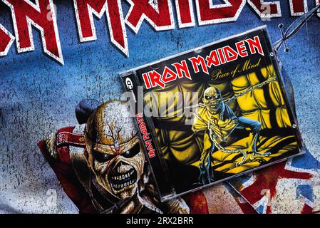 Nahaufnahme des Covers der Piece of Mind-CD von Iron Maiden auf einem T-Shirt mit dem Iron Maiden-Logo. Iron Maiden ist eine britische Heavy-Metal-Band Stockfoto