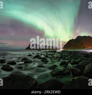 Wellen stürzen auf Felsen am Uttakleiv Strand unter den Nordlichtern, Vestvagoy, Lofoten Inseln, Nordland, Norwegen, Skandinavien Stockfoto