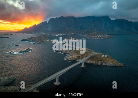 Luftaufnahme einer Brücke über den Fjord unter einem dramatischen Himmel bei Sonnenuntergang, reine Bay, Lofoten-Inseln, Nordland, Norwegen, Skandinavien, Europa Stockfoto