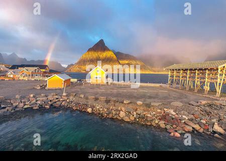 Panoramaaussicht auf den traditionellen Rorbu- und Olstind-Gipfel unter dem Regenbogen, Sakrisoy, reine, Lofoten-Inseln, Nordland, Norwegen, Skandinavien, Europa Stockfoto