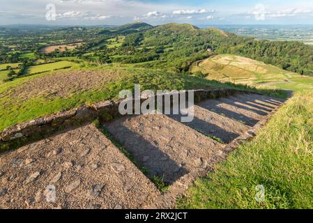 Steintreppen, die nach Norden, hinunter zu den Malverns, vom Gipfel des Hügels aus der Eisenzeit, auf der Spitze des Herefordshire Beacon, führen. Stockfoto