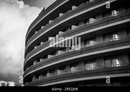 Schwarz-weiß abgerundetes Hotel oder Apartments in einer spanischen Stadt mit vulkanischen Inseln am Meer Stockfoto