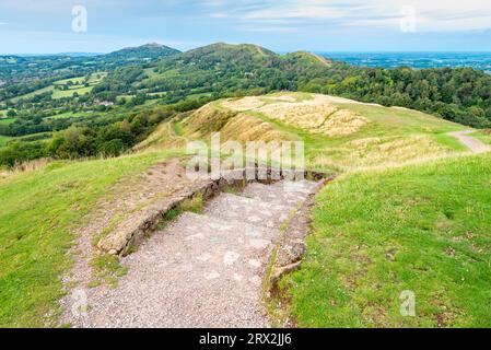 Steintreppen, die nach Norden, hinunter zu den Malverns, vom Gipfel des Hügels aus der Eisenzeit, auf der Spitze des Herefordshire Beacon, führen. Stockfoto