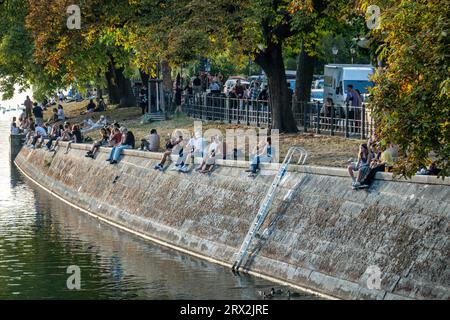 Leute sitzen im Landwehrkanal Berlin Kreuzberg, Urbanhafen, Herbst Stockfoto