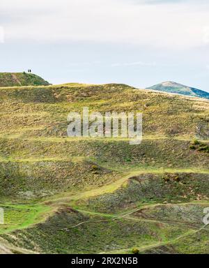 Entfernte Bergwanderer stehen auf dem Gipfel des Herefordshire Beacon und blicken nach Norden zu den berühmten Gipfeln von Malvern Hills und Worcestershire Beaco Stockfoto