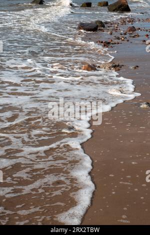 Schaumiger Strand mit Meereswellen Stockfoto