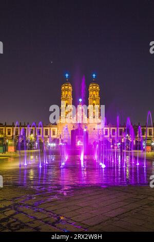 Zapopan Basilika, Guadalajara, Mexiko, beleuchtet von Scheinwerfern bei Nacht und von farbigen Wasserfontänen im Vordergrund. Stockfoto