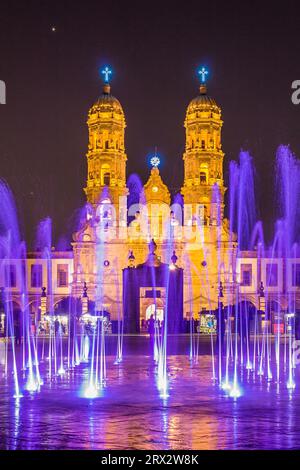 Zapopan Basilika, Guadalajara, Mexiko, beleuchtet von Scheinwerfern bei Nacht und von farbigen Wasserfontänen im Vordergrund. Stockfoto