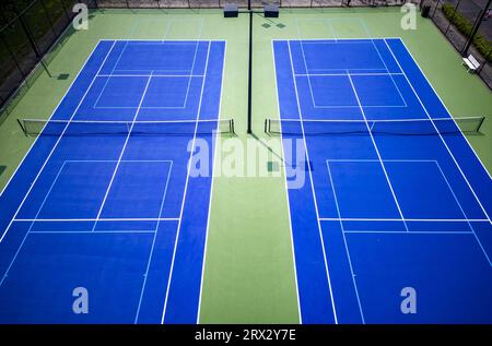 Drone View auf neu gemalte blau-weiße Pickleball Tennis Couts mit Lichtern. Stockfoto