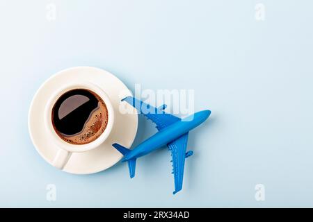 Kaffee mit Flugzeugmodell auf blauem Hintergrund. Stockfoto