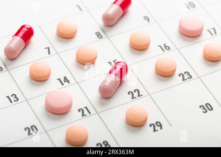 Die Pillen haben eine andere Farbe im Kalender. Medikamente einplanen. Konzentrieren Sie sich auf eine hellgrüne Pille. Hochwertige Fotos Stockfoto