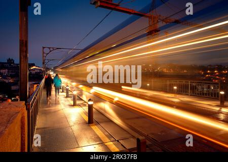 Porto U-Bahn entlang der Oberseite der Ponte Dom Luis Brücke bei Nacht, verschwommene Bewegung und Beleuchtung Stockfoto