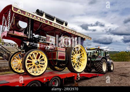 Boat of Garten Dampfkundgebung, die eine große Zugmaschine aus dem Anhänger entlädt Stockfoto