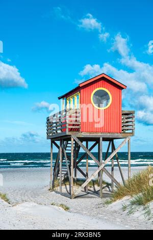 Roter hölzerner Rettungsschwimmer-Aussichtsturm auf Stelzen an der Strandbar in den Sanddünen am Strand Skanör med Falsterbo in der Morgensonne, Skåne, Schweden Stockfoto