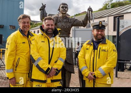 North Shields, North Tyneside, Großbritannien. September 2023. Launch Event of the Herring Girl - eine neue Skulptur von Ray Lonsdale am Fish Quay der Stadt, mit einer Parade, Live-Musik von örtlichen Schulen und Mitgliedern der Gruppe Lindisfarne, Reden, einer Segeltour vorbei an Schiffen und der Enthüllung der Skulptur. Das Projekt wurde vom North Shields Fishers's Heritage Project geleitet, das vom North Tyneside Council unterstützt wurde. - Das RNLI mit der Skulptur. Quelle: Hazel Plater/Alamy Live News Stockfoto