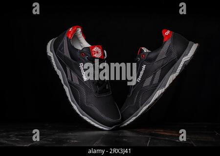 Kiew, Ukraine - 5. September 2023: Reebok graue Turnschuhe isoliert auf schwarzem Hintergrund Stockfoto