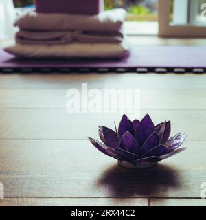 Glaslotus dekorativ auf einem Holzboden. Yoga-Konzept Stockfoto