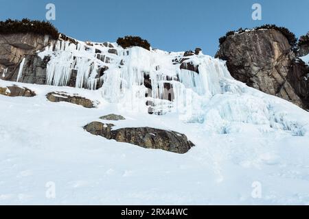 Gefrorener Wasserfall Skok in der Hohen Tatra (Slowakei) im Winter. Großer Wasserfall mit blauem Riesenkikel Frost auf den Felsen. Stockfoto