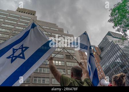 New York, USA. September 2023. Hunderte Aktivisten versammeln sich gegen die von der Regierung vorgeschlagenen Justizreformen vor der israelischen Mission bei der UNO auf der 2nd Avenue in New York, als Premierminister Benjamin Netanjahu am 22. September 2023 zu Besuch war. Die Rally fand statt, nachdem der Premierminister während der 78. Tagung der Generalversammlung der Vereinten Nationen eine Rede gehalten hatte. Israelische Flagge auf der Spitze der Mission durch Demonstranten gesehen. (Foto: Lev Radin/SIPA USA) Credit: SIPA USA/Alamy Live News Stockfoto