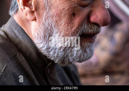 Das Gesicht des alten Mannes lächelt mit dem bärtigen Gesicht in grauer Farbe Stockfoto