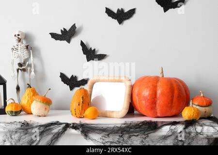 Halloween Kürbisse mit Rahmen und Skelett am Kamin im Zimmer Stockfoto