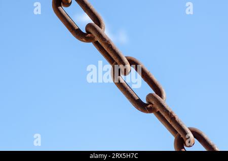 Rostige Ketten Backsteinhintergrund, ein Symbol für Stärke und Unterdrückung, in der Industrie in Brechstangen sowie in der Sklaverei verwendet. Sehr große Kettenglieder. Stockfoto