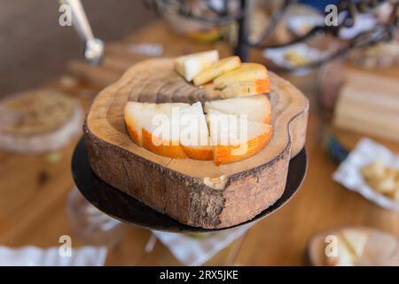 Halbgereifter geräucherter Paprikakäse auf Baumrindenschale. Nahaufnahme Stockfoto