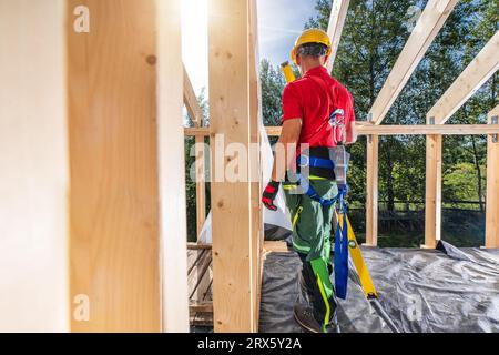 Professioneller Bauunternehmer, Der Sicherheitsgurte Im Neu Gebauten Hölzernen Skelettrahmen Trägt Stockfoto