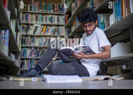 Junger Student, Buchliebhaber, der Freizeit in der Bibliothek verbringt Stockfoto