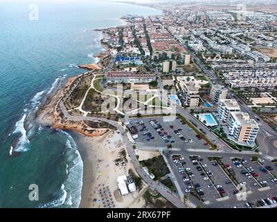 Spanien, Valencianische Gemeinschaft, MIL Palmeras, Luftaufnahme der Küstenstadt mit Parkplatz am Strand im Vordergrund Stockfoto